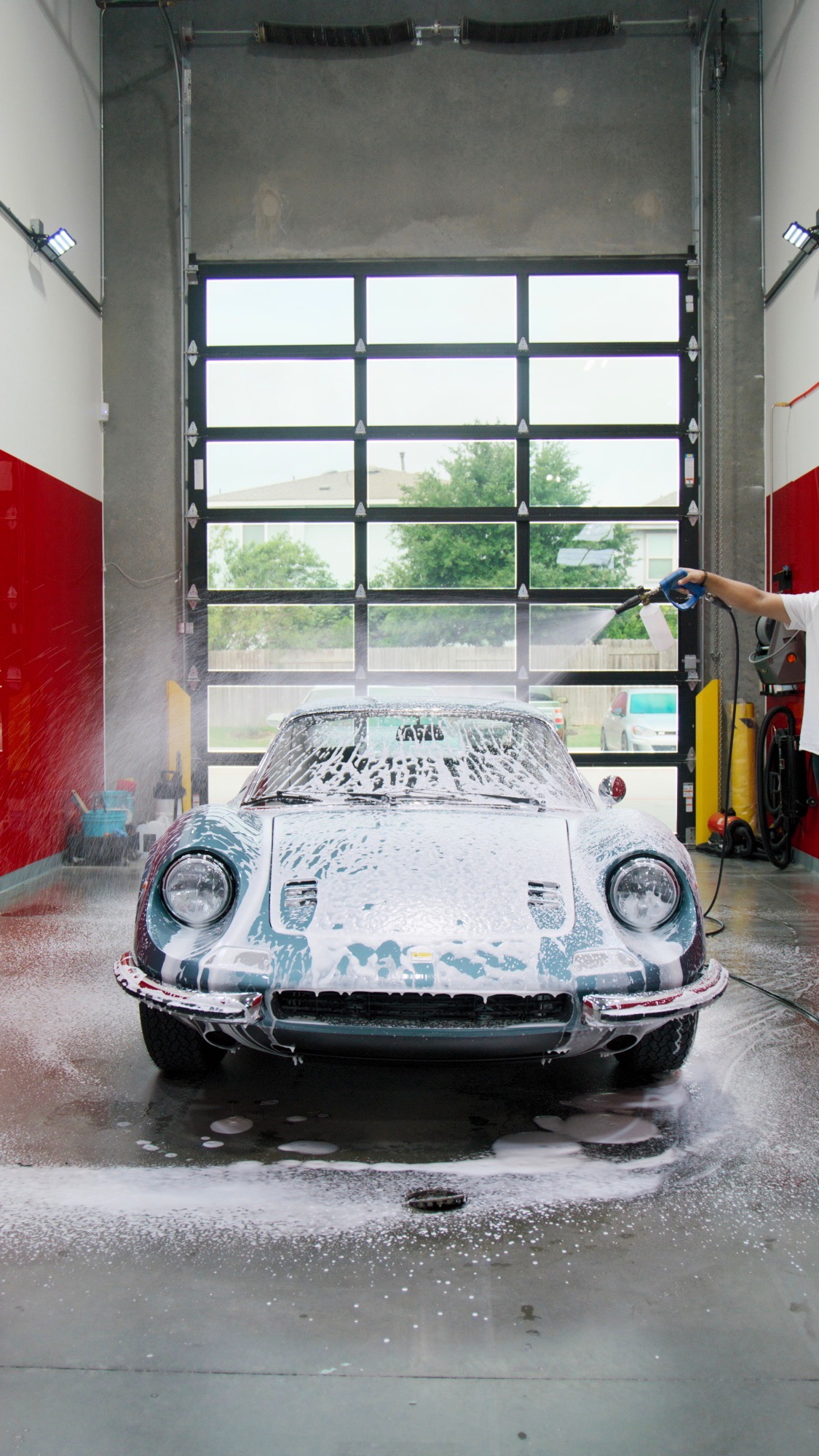 Classic Ferrari Dino foam-washed in the Red Box Restoration detailing bay